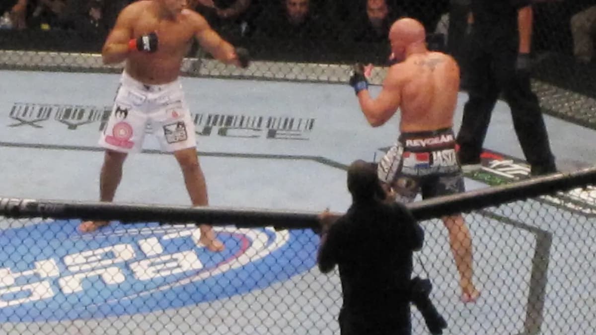 An empty UFC Octagon lit under arena lights ahead of a fight card