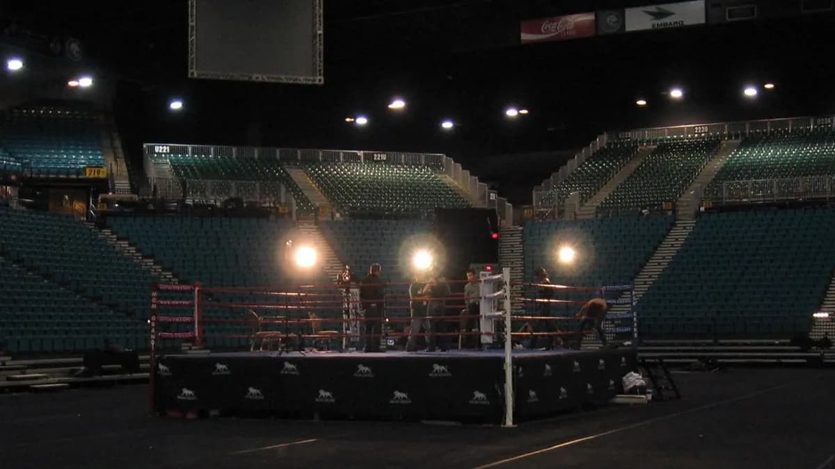A boxing ring under bright arena lights ahead of a fight night